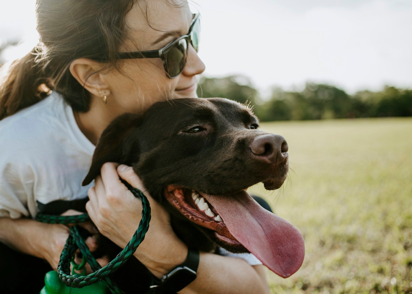 A woman embracing her dog outdoors